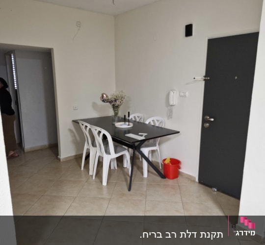 דלת אפורה עם ידית כסופה וקיר לבן